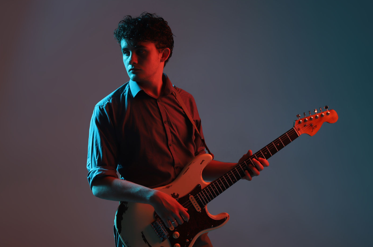 Harvey playing guitar with coloured lighting